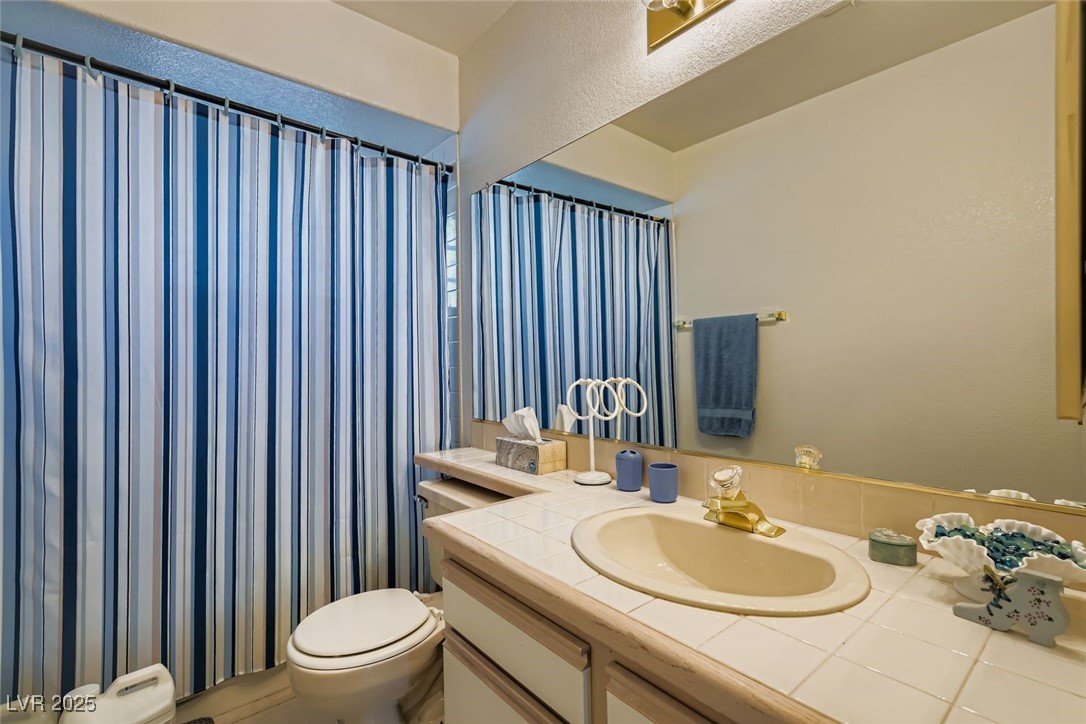6800 West Elm Creek Drive, Unit 103 Las Vegas, NV 89108 - Photo 20 of 22 Bathroom with vanity and curtained shower