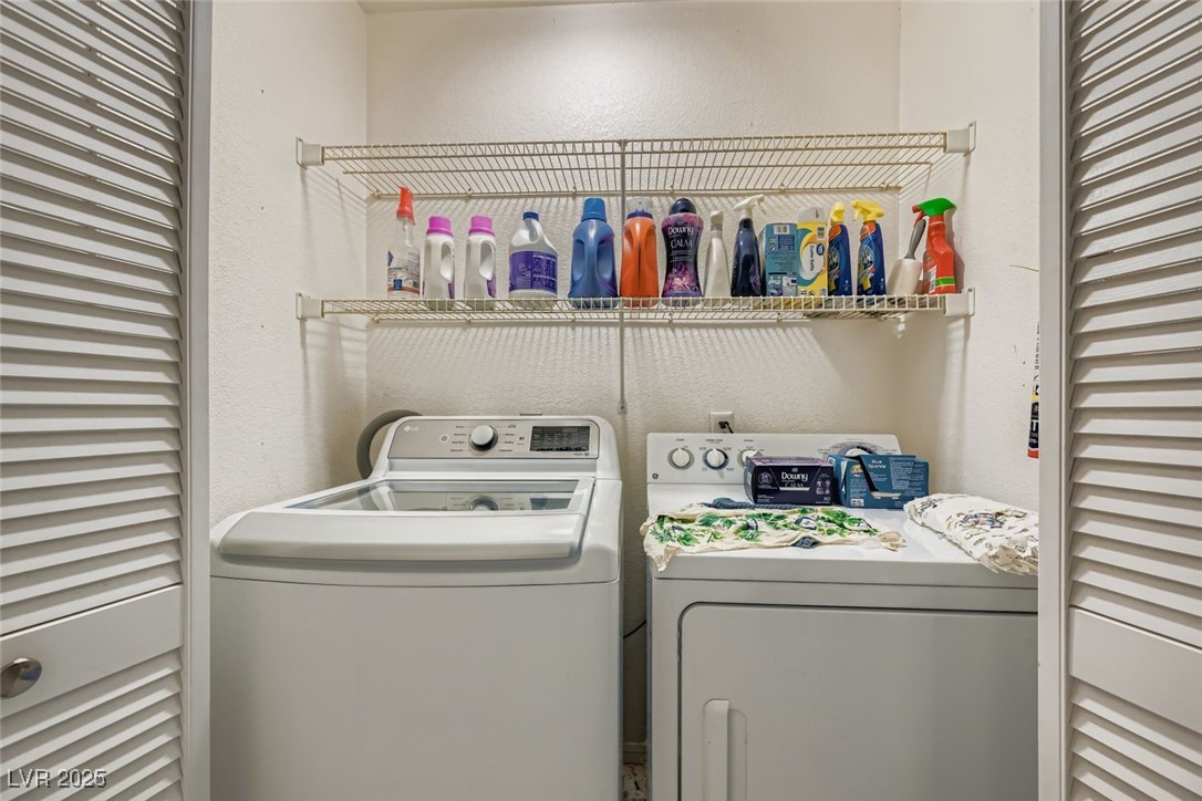 6800 West Elm Creek Drive, Unit 103 Las Vegas, NV 89108 - Photo 21 of 22 Laundry room featuring a textured wall and washing machine and dryer