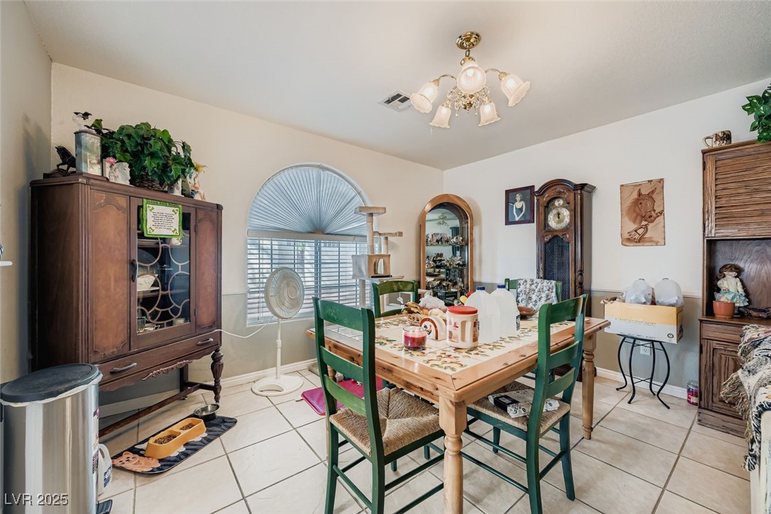 6800 West Elm Creek Drive, Unit 103 Las Vegas, NV 89108 - Photo 9 of 22 Dining area with light tile patterned floors and a chandelier