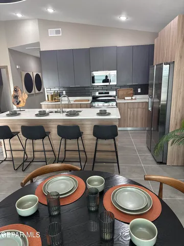 a kitchen with a sink a stove and chairs