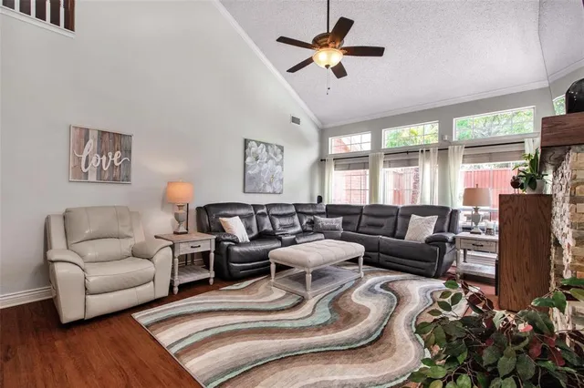 a living room with furniture ceiling fan and a large window
