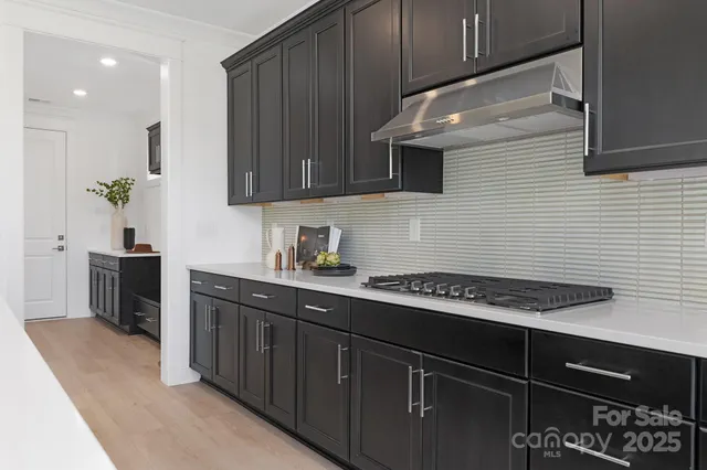 a kitchen with stainless steel appliances a sink dishwasher stove refrigerator and cabinets