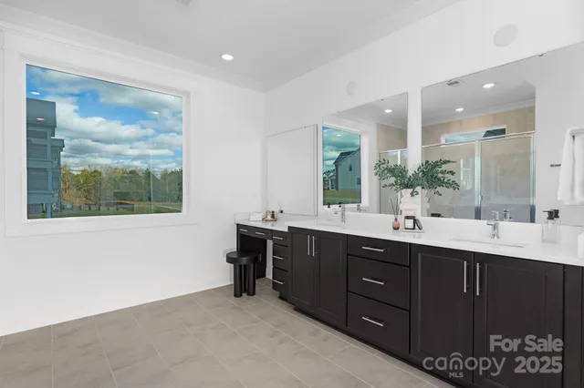 a spacious bathroom with a double vanity sink a mirror and a bathtub