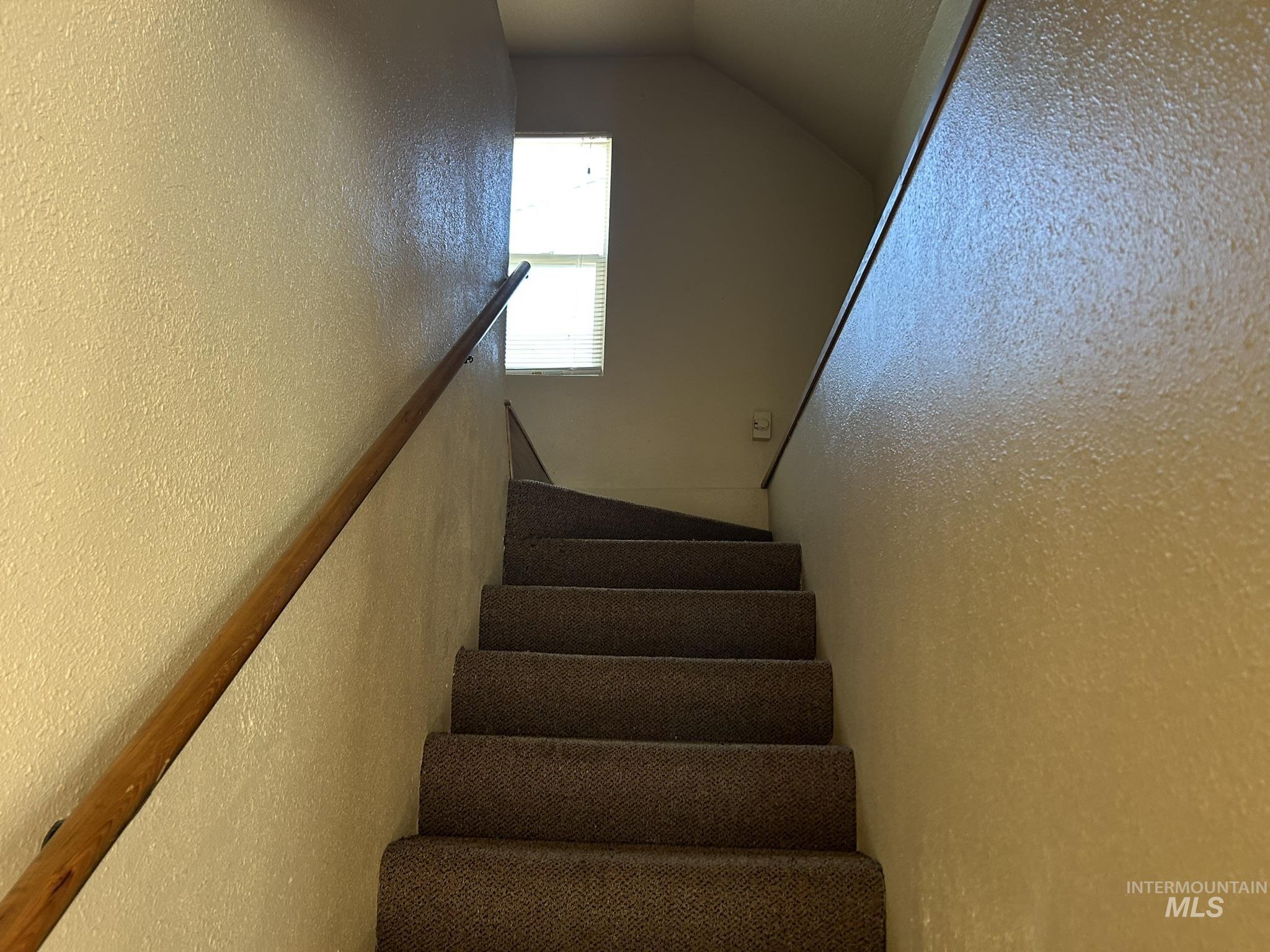 1413 7th Avenue Lewiston, ID 83501 - Photo 9 of 15 Staircase featuring a textured wall and vaulted ceiling
