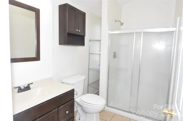 a bathroom with a granite countertop toilet sink and mirror