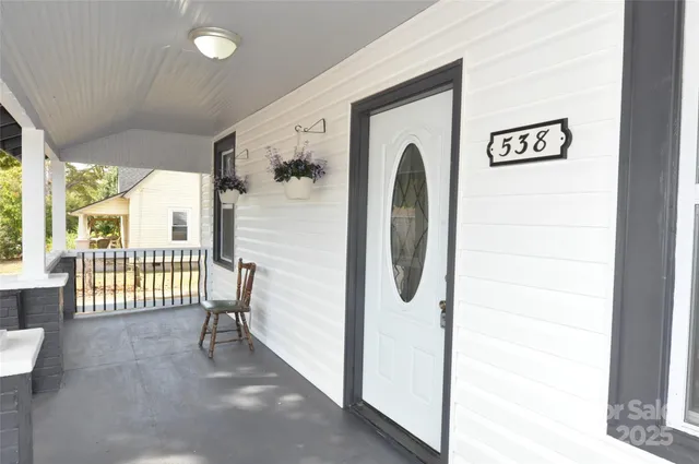 a view of a hallway with a door and wooden floor