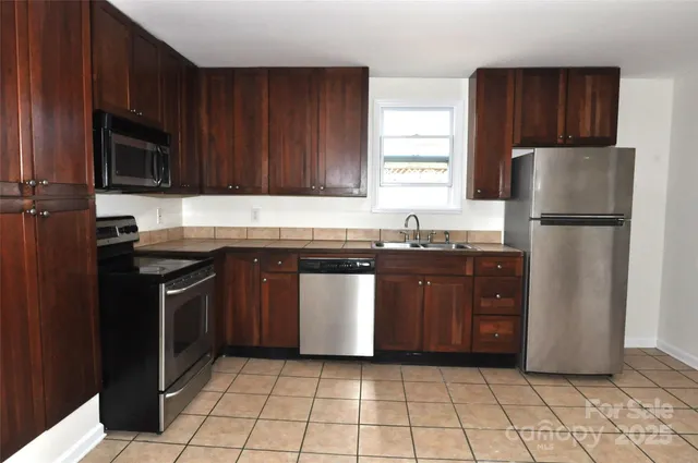 a kitchen with a stove a refrigerator and a sink