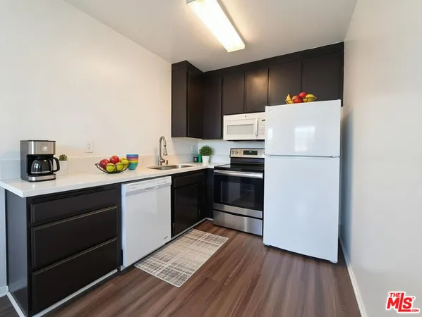 a kitchen with a refrigerator and a stove top oven