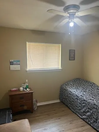 a bedroom with a bed and wooden floor