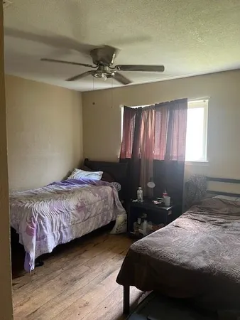 a bedroom with a bed and wooden floor
