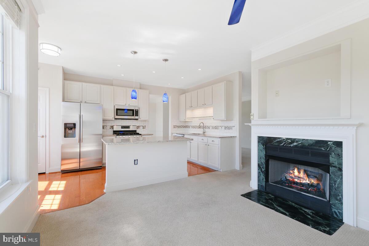 130 Chevy Chase Street, Unit 404 Gaithersburg, MD 20878 - Photo 14 of 39 a open kitchen with cabinets and a fireplace