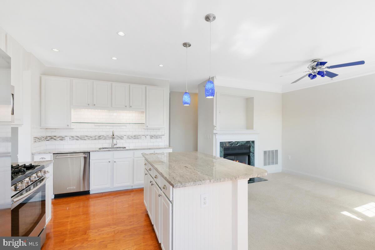 130 Chevy Chase Street, Unit 404 Gaithersburg, MD 20878 - Photo 16 of 39 a kitchen with granite countertop a sink a stove and cabinets