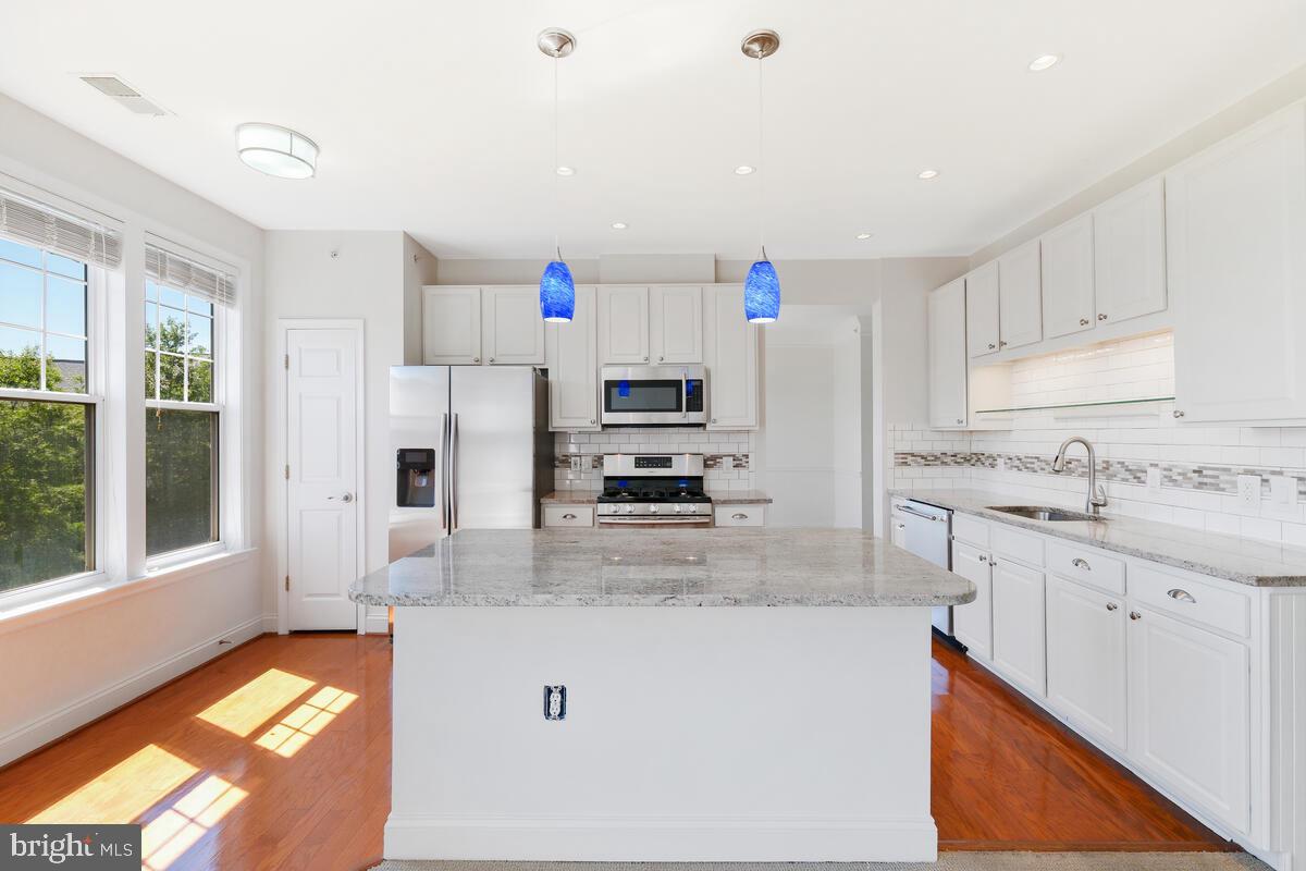 130 Chevy Chase Street, Unit 404 Gaithersburg, MD 20878 - Photo 17 of 39 a kitchen with stainless steel appliances granite countertop a sink stove and refrigerator