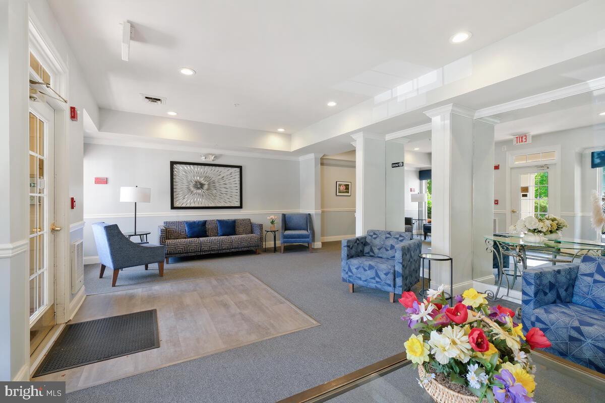130 Chevy Chase Street, Unit 404 Gaithersburg, MD 20878 - Photo 5 of 39 a living room with furniture and flowers