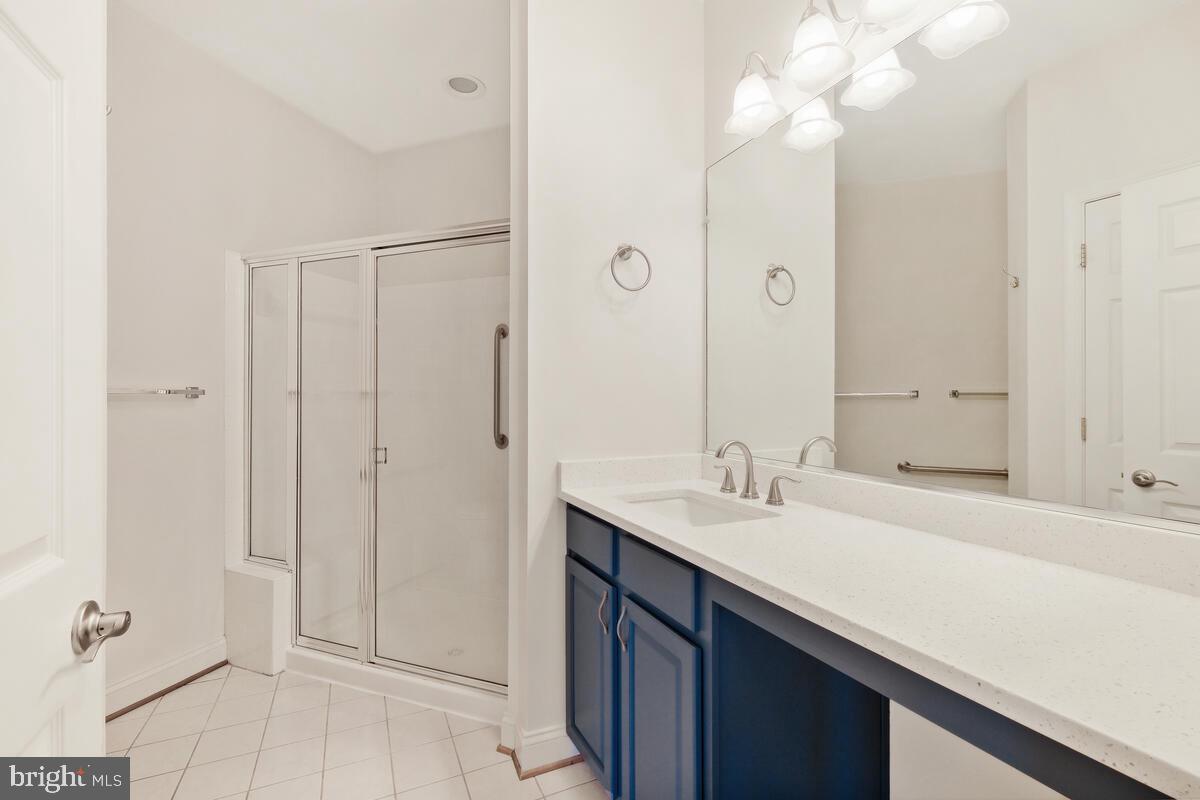 130 Chevy Chase Street, Unit 404 Gaithersburg, MD 20878 - Photo 10 of 39 a bathroom with a sink a mirror and a shower