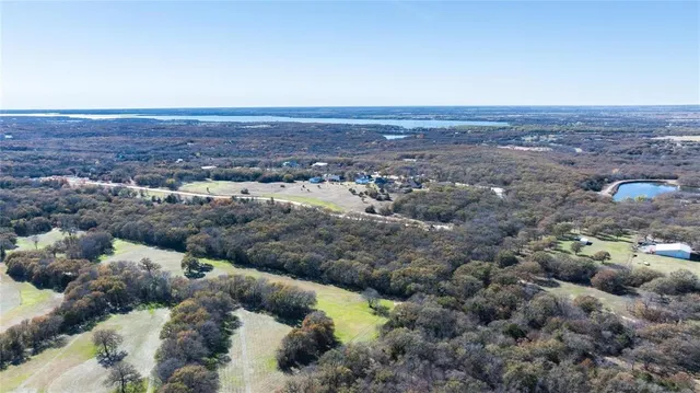 an aerial view of house with yard and mountain in the background