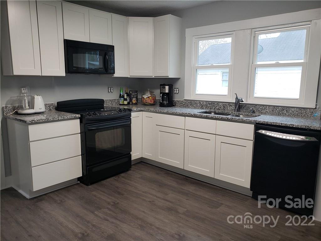 473 Liberty Drive Southwest Concord, NC 28027 - Photo 17 of 19 a kitchen with granite countertop a stove a sink and a microwave
