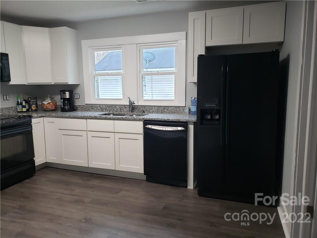 473 Liberty Drive Southwest Concord, NC 28027 - Photo 18 of 19 a kitchen with granite countertop white cabinets and refrigerator