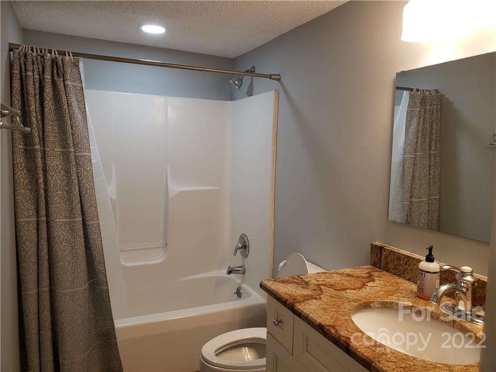 473 Liberty Drive Southwest Concord, NC 28027 - Photo 8 of 19 a bathroom with a granite countertop sink toilet and shower