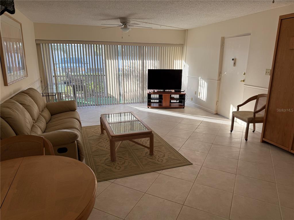 7701 Starkey Road, Unit 703 Seminole, FL 33777 - Photo 4 of 23 a living room with furniture a flat screen tv and a large window