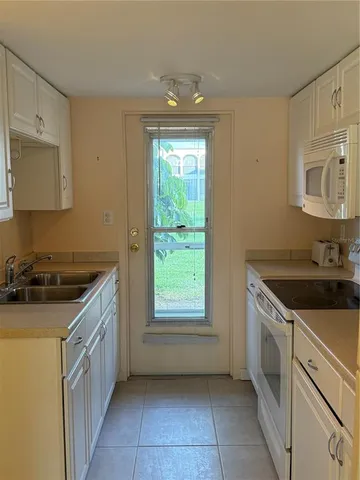 a kitchen with white cabinets and white appliances