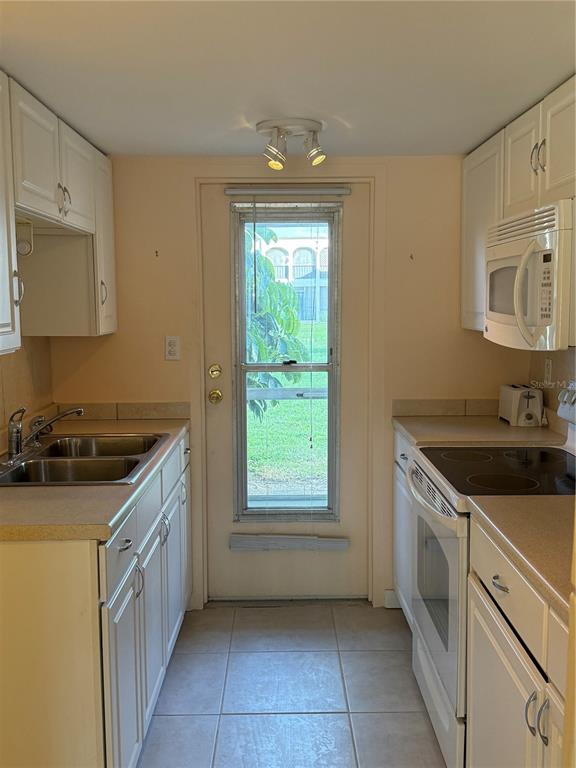 7701 Starkey Road, Unit 703 Seminole, FL 33777 - Photo 7 of 23 a kitchen with a sink stove and cabinets