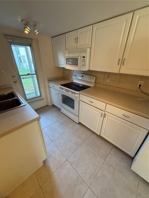 7701 Starkey Road, Unit 703 Seminole, FL 33777 - Photo 8 of 23 a kitchen with cabinets and appliances