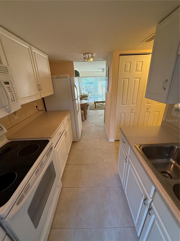 7701 Starkey Road, Unit 703 Seminole, FL 33777 - Photo 10 of 23 a kitchen with a sink and wooden cabinets