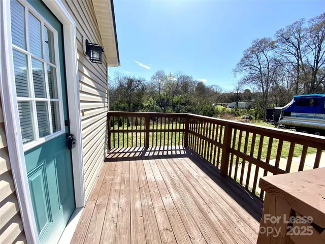 a view of a balcony with wooden floor and fence
