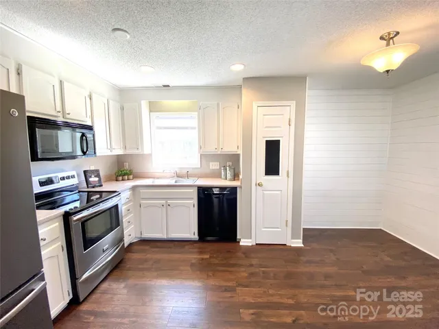 a kitchen with a stove a sink and a refrigerator