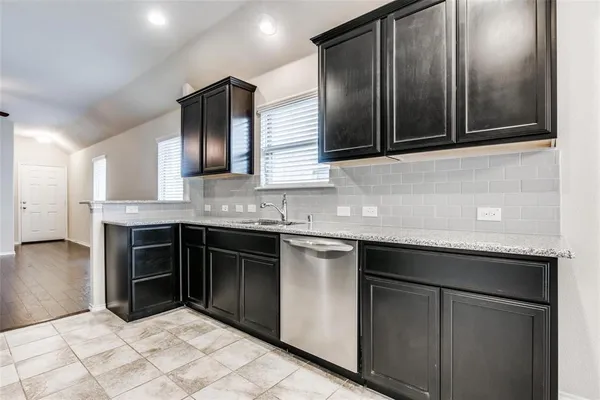 a kitchen with stainless steel appliances granite countertop a sink and a stove