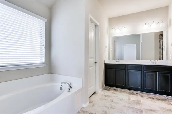 a bathroom with a bathtub sink and mirror