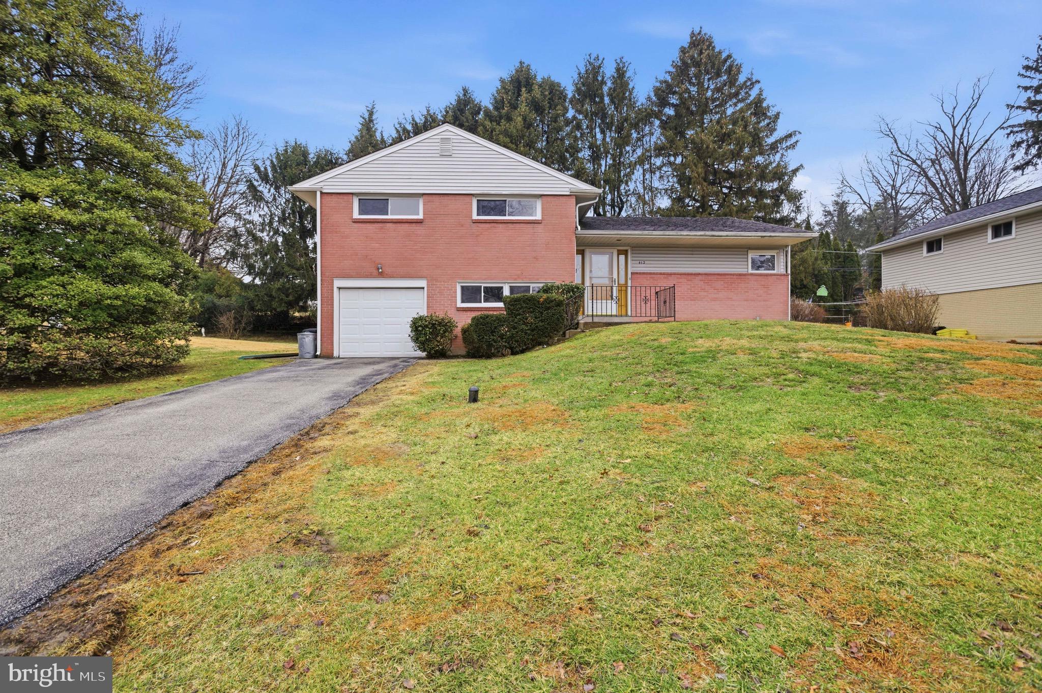 412 Foster Drive Springfield, PA 19064 - Photo 1 of 34 a front view of a house with a yard and garage