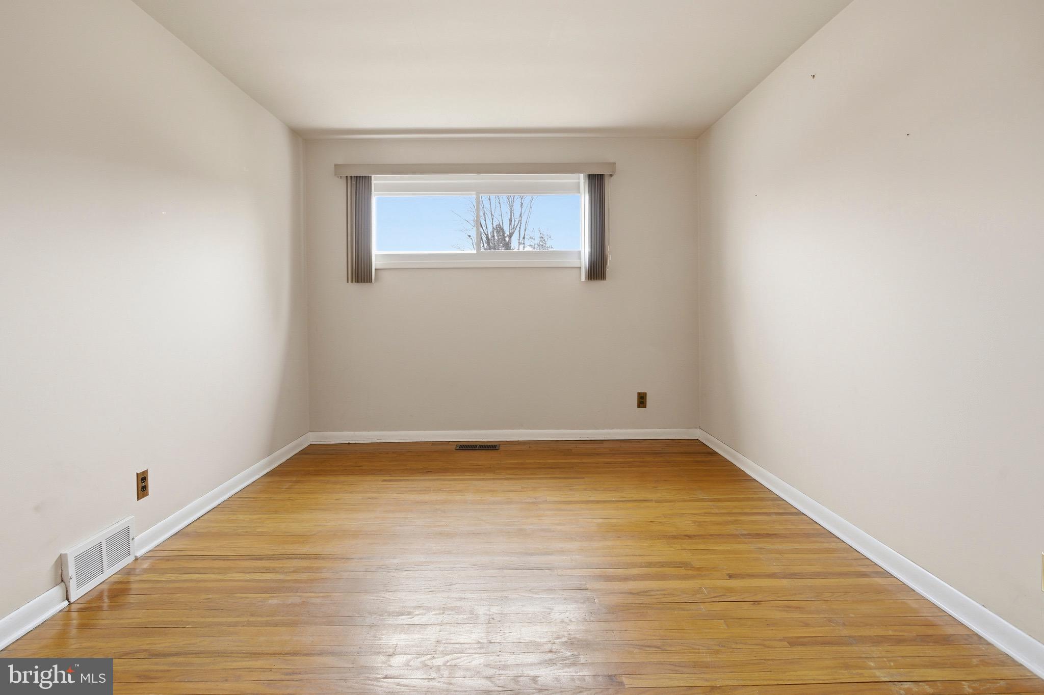 412 Foster Drive Springfield, PA 19064 - Photo 19 of 34 a view of an empty room with wooden floor and a window