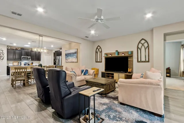 a view of a dining room with furniture a chandelier and wooden floor