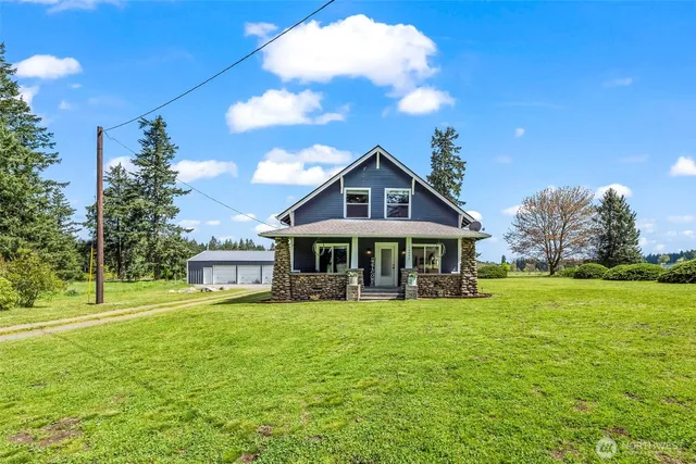 a view of a house with a big yard and large trees