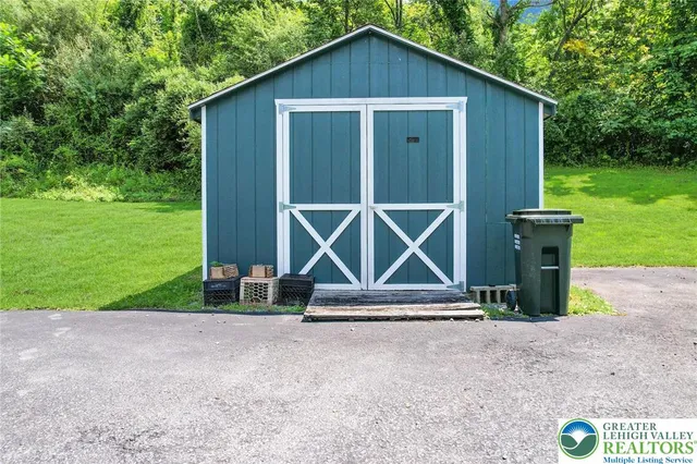 a view of an house with backyard and trees