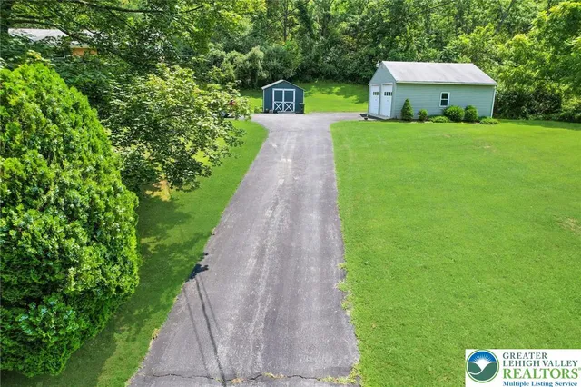 a front view of a house with a yard and trees