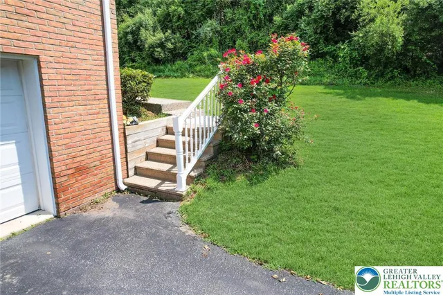 a view of a house with a yard and potted plants