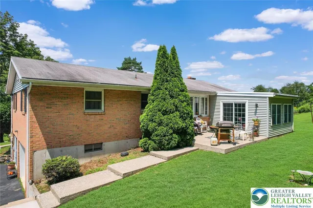 a front view of a house with garden and yard
