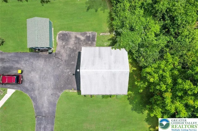 an aerial view of a house with a yard and trees