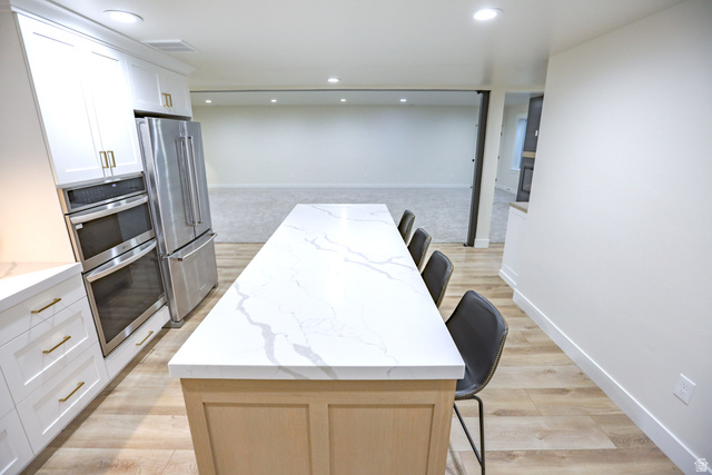 126 North 800 West Mapleton, UT 84664 - Photo 54 of 79 Kitchen featuring a breakfast bar, light stone counters, light wood-style floors, stainless steel appliances, and recessed lighting