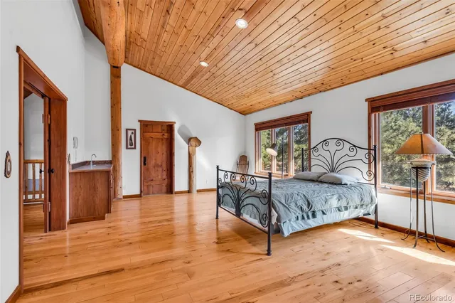 a spacious bedroom with a large bed and a chandelier