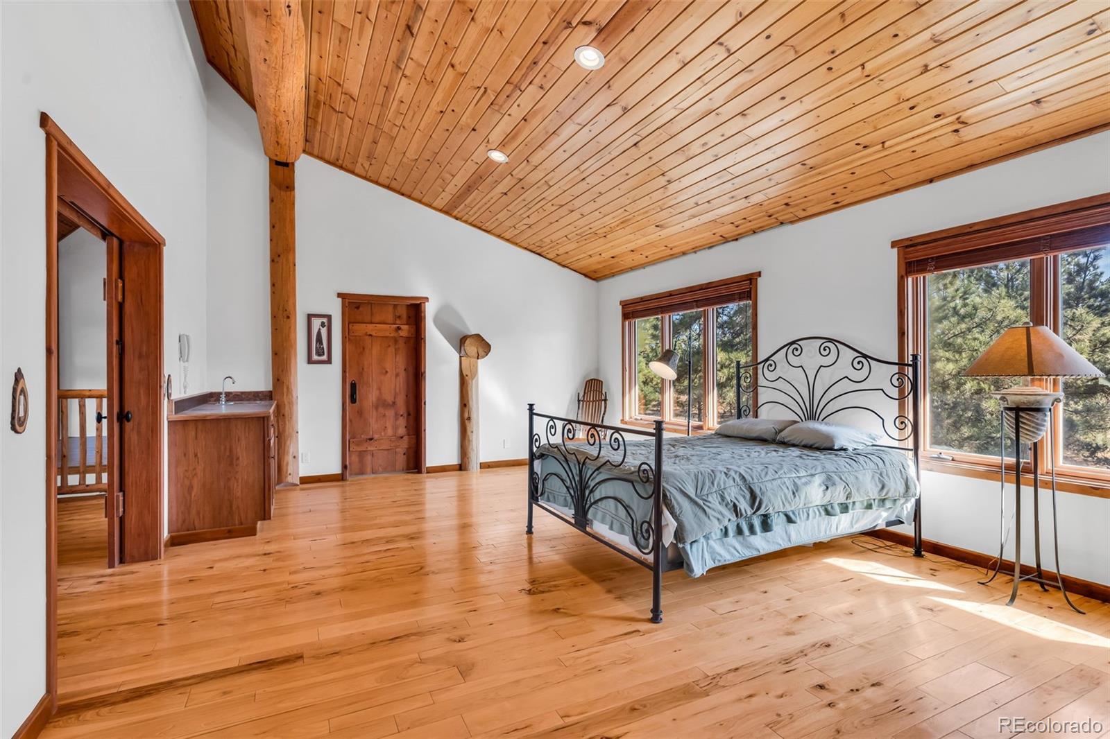 23100 Spirit Mountain Road Aguilar, CO 81020 - Photo 12 of 41 a spacious bedroom with a large bed and a chandelier