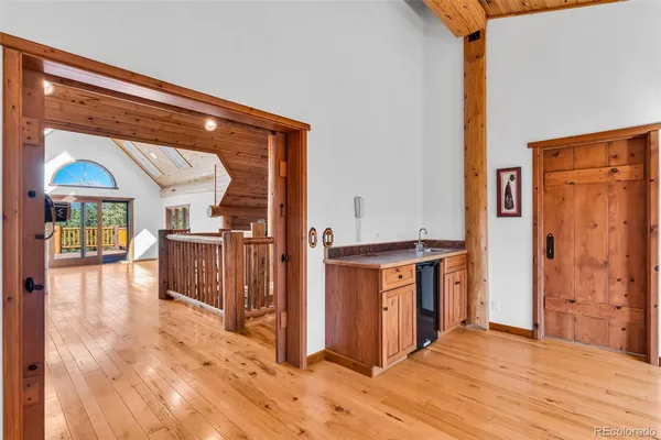 a view of front door with hallway and wooden floor