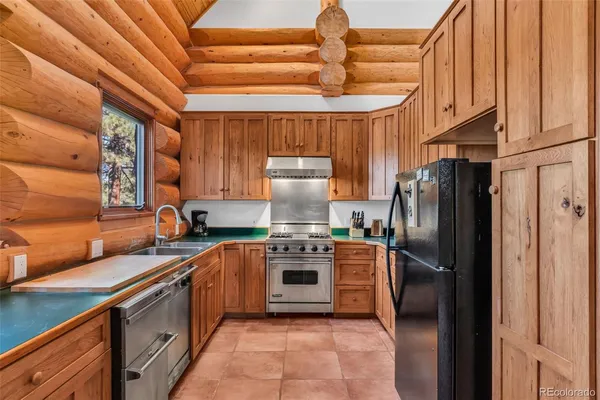 a kitchen with stainless steel appliances granite countertop a refrigerator and a stove top oven