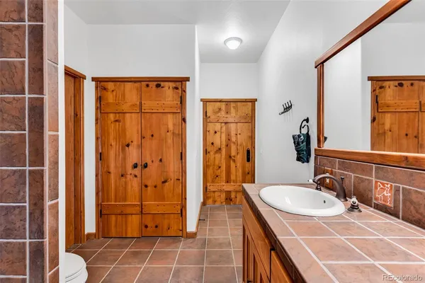 a bathroom with a granite countertop sink a mirror and shower