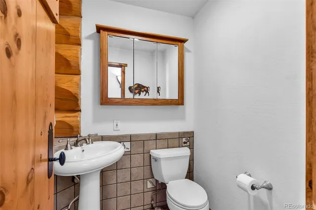a bathroom with a toilet sink and mirror