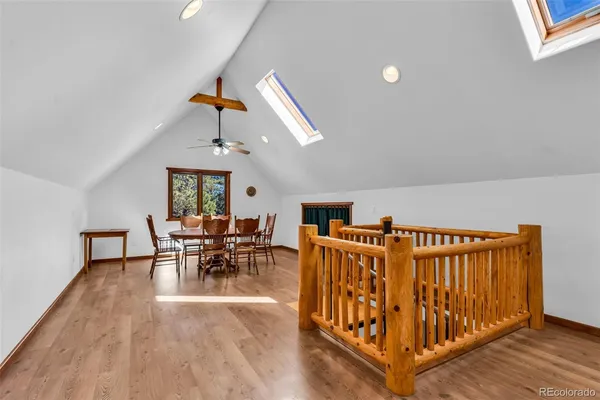 a dining room with furniture wooden floor carpet and a chandelier