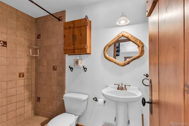 a bathroom with a toilet sink and mirror